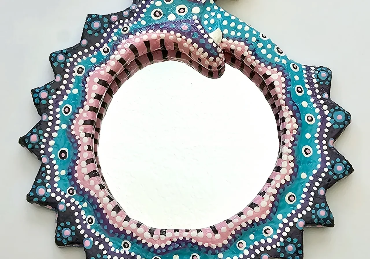 A mirror with a snake design on it